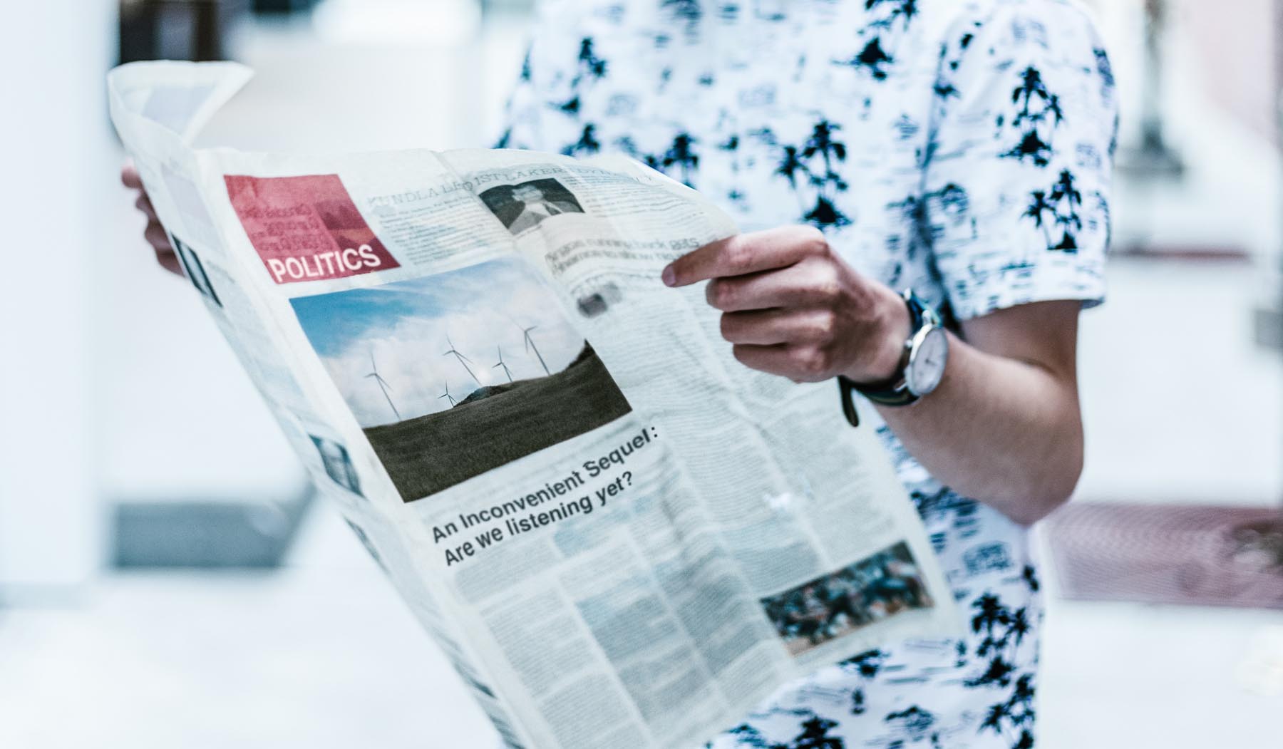 Person holding the newspaper, reading